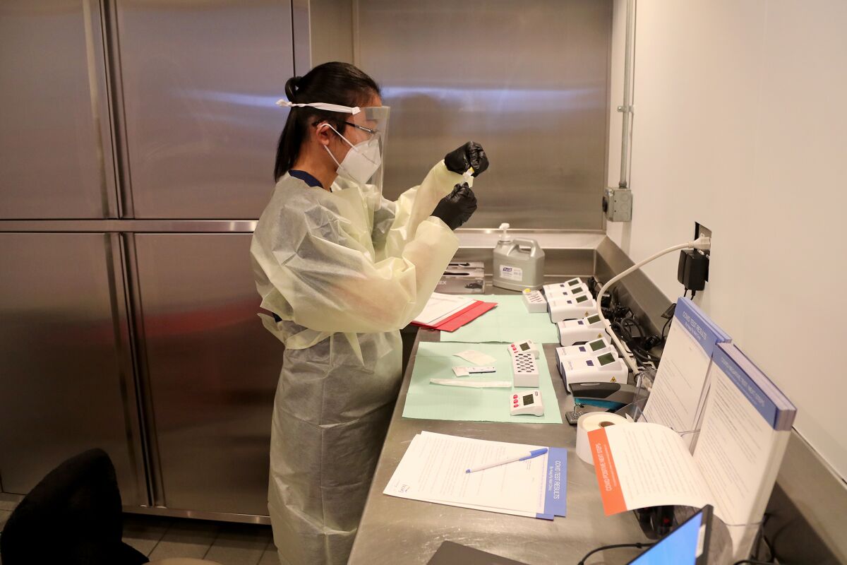 Nurse practitioner JoAnn Escalante-Alviz prepares a COVID-19 test at Hoag's rapid testing clinic at John Wayne Airport.