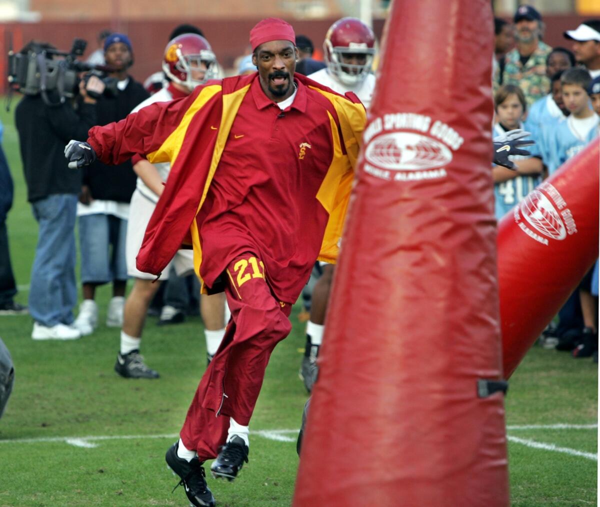 Snoop Dogg knocks down tackling dummies during a visit with the USC football team in 2004. He spoke up for the No. 14 Trojans on ESPN on Friday, picking them to top No. 13 Stanford.