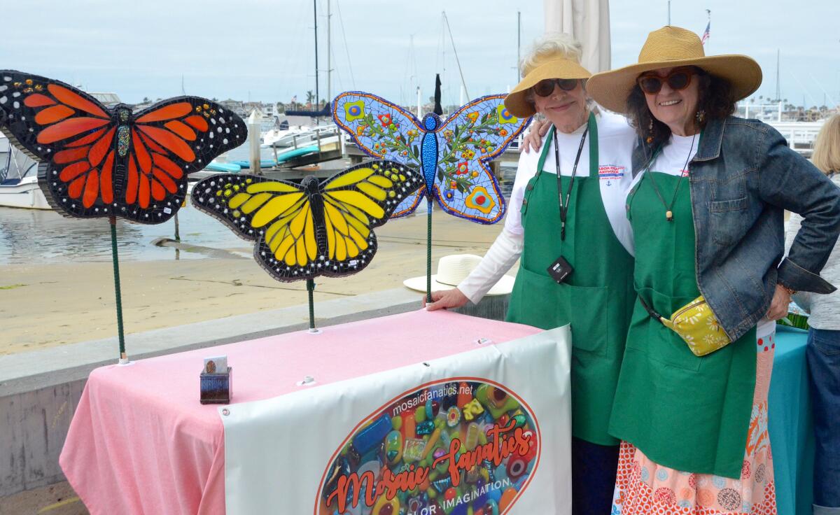 Mosaic-Fanatics partners Lani Wilson, left, and Sandy Stevens stand alongside their mosaic butterflies.