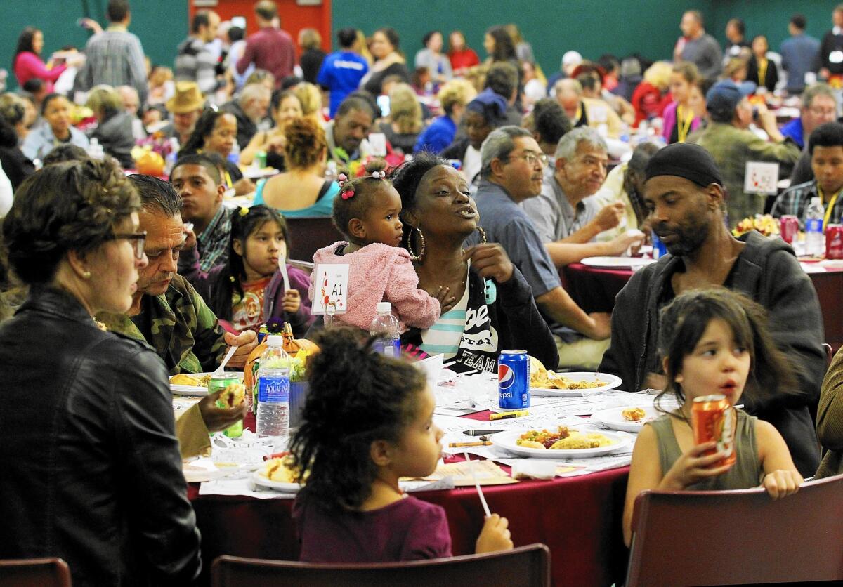 Vinique Buyard and her daughter Keiaa Lucas, 1, join hundreds of other guests for a Thanksgiving dinner hosted by the San Fernando Valley Rescue Mission at the Church on the Way in Van Nuys.