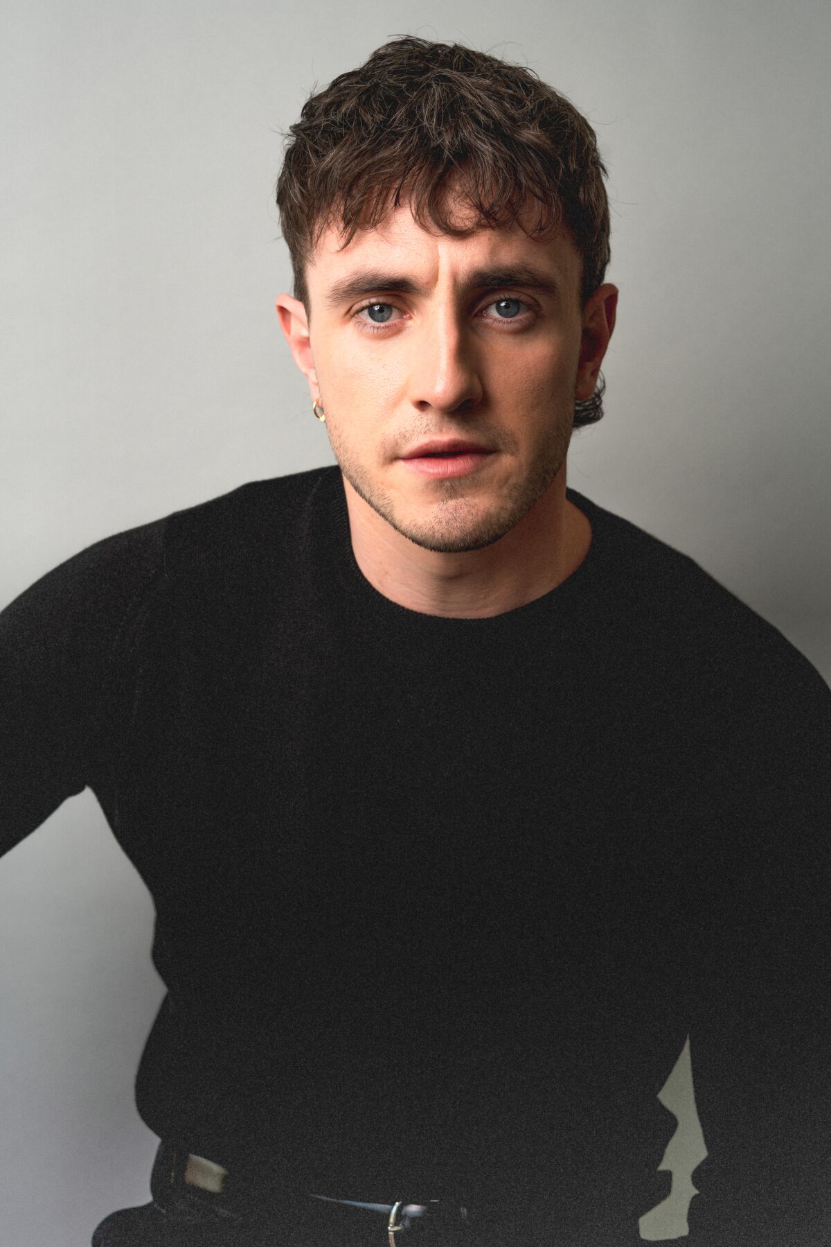 Paul Mescal wears a black long-sleeved shirt for a portrait.