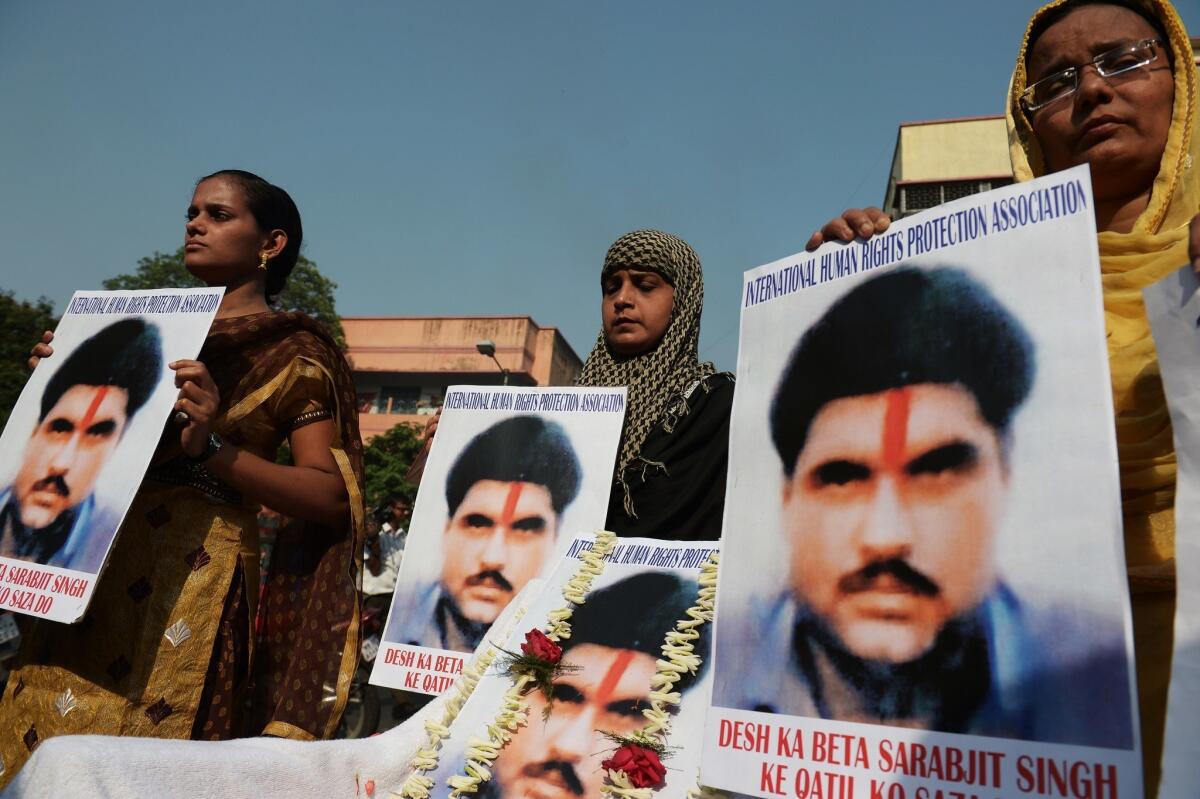 Indian activists pose with pictures of deceased inmate Sarabjit Singh in Kolkata on May 2, 2013.