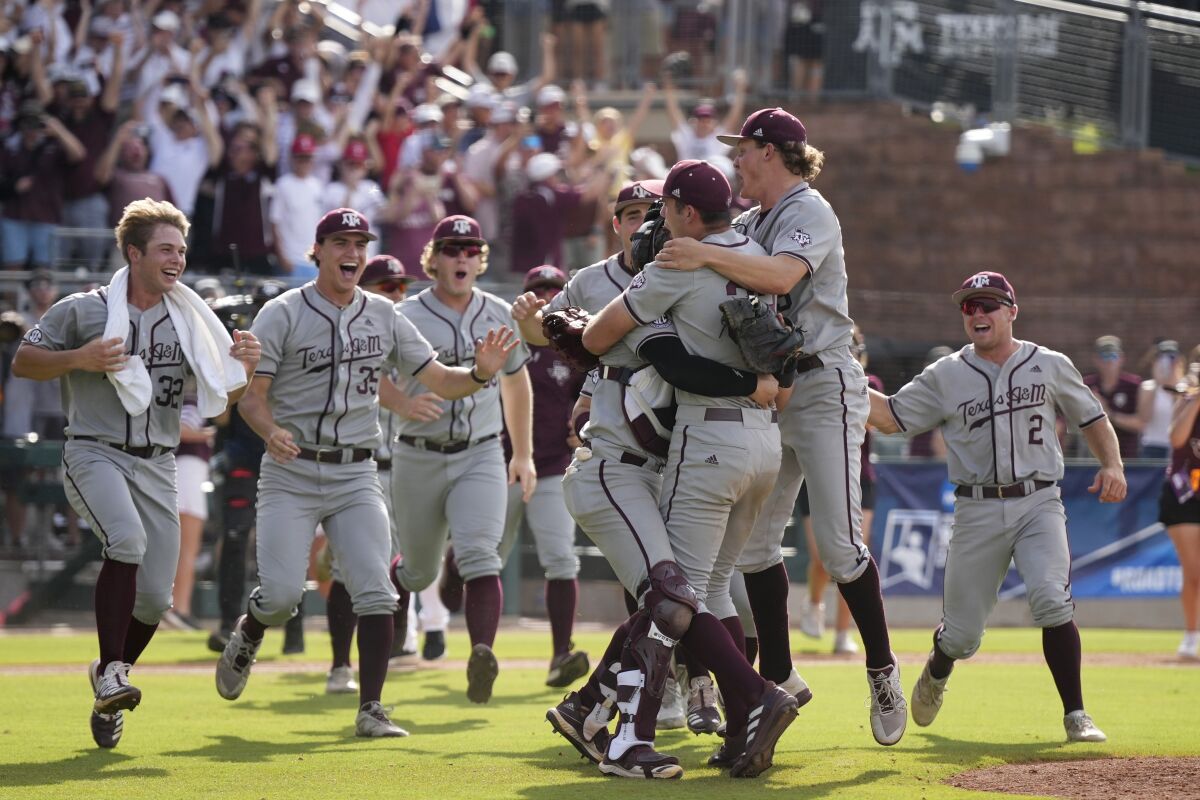 Texas A&M pitcher Jacob Palisch (33) and catcher Troy Claunch (12) celebrate after the final out against Louisville during an NCAA college baseball super regional tournament game Saturday, June 11, 2022, in College Station, Texas. (AP Photo/Sam Craft)