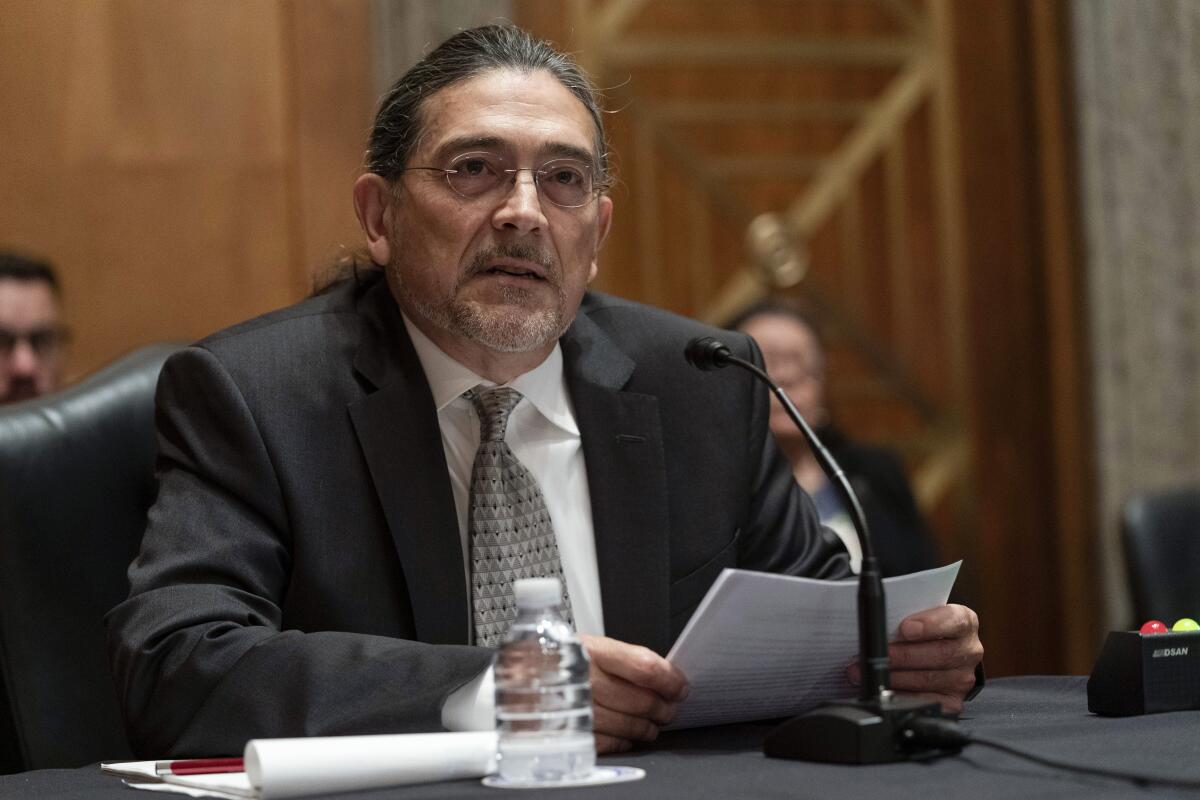 Robert Santos speaks into a microphone during his hearing. 
