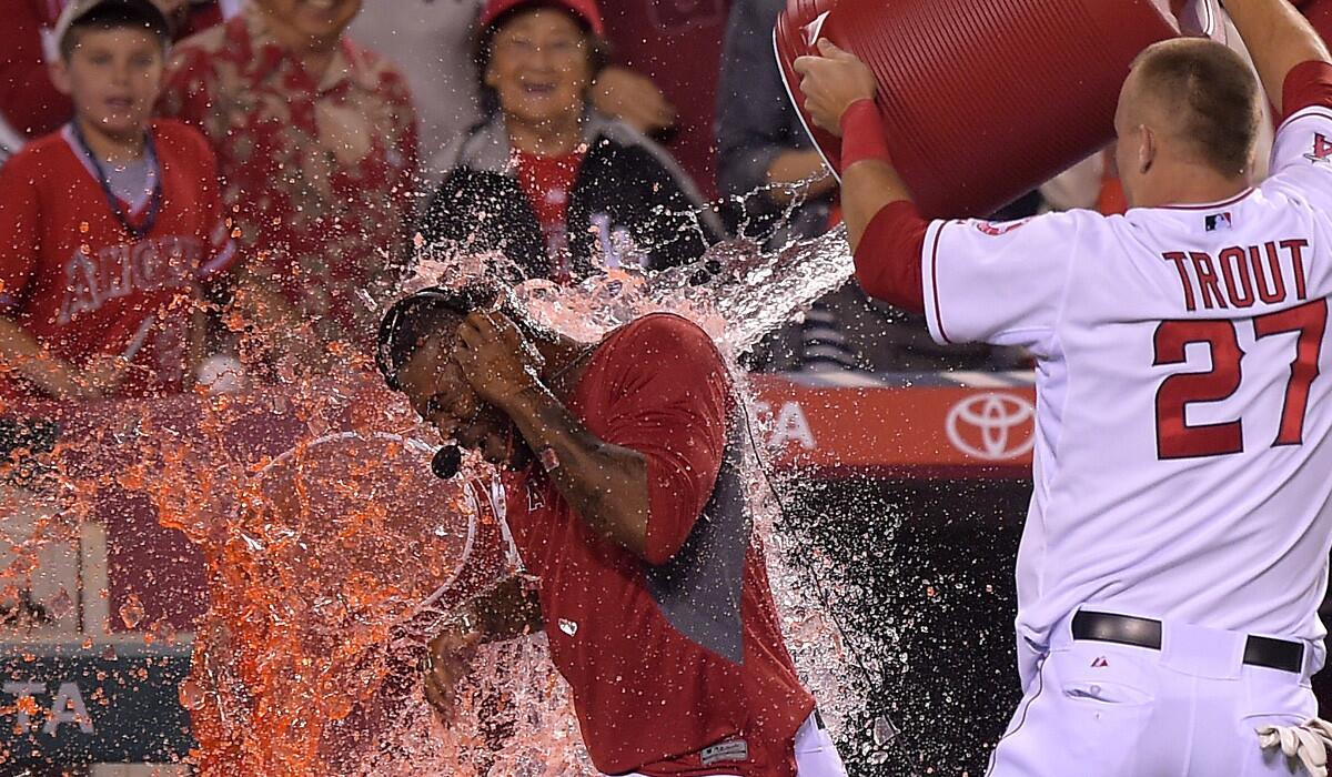 Angels outfielder Mike Trout gives second baseman Howie Kendrick a victory shower during his postgame interview Saturday night in Anaheim.