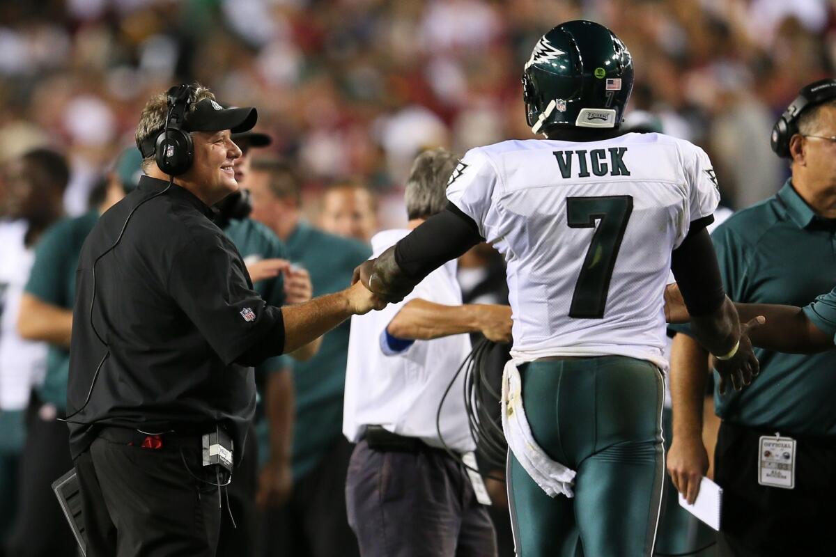 Philadelphia Eagles Coach Chip Kelly, left, smiles as bumps fists with quarterback Michael Vick during last week's game against the Washington Redskins. NFL analyst Jon Gruden has worked extensively with Kelly over the years.
