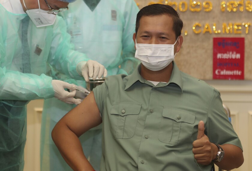 Cambodia's Lt. Gen. Hun Manet, a son of Prime Minister Hun Sen, thumbs up as he receives a shot of the COVID-19 vaccine at Calmette hospital in Phnom Penh, Cambodia, Wednesday, Feb. 10, 2021. Cambodia began its inoculation campaign against the COVID-19 virus with vaccines donated from China, the country’s closest ally. (AP Photo/Heng Sinith)