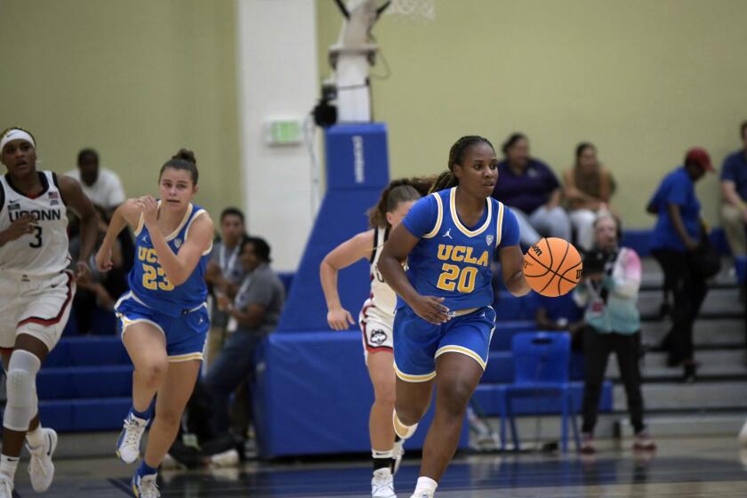 UCLA's Charisma Osborne (20) brings the ball upcourt during the second half of an NCAA college basketball game against UConn at the Cayman Islands Classic in George Town, Cayman Islands, Friday, Nov. 24, 2023. (AP Photo/Kevin Morales)