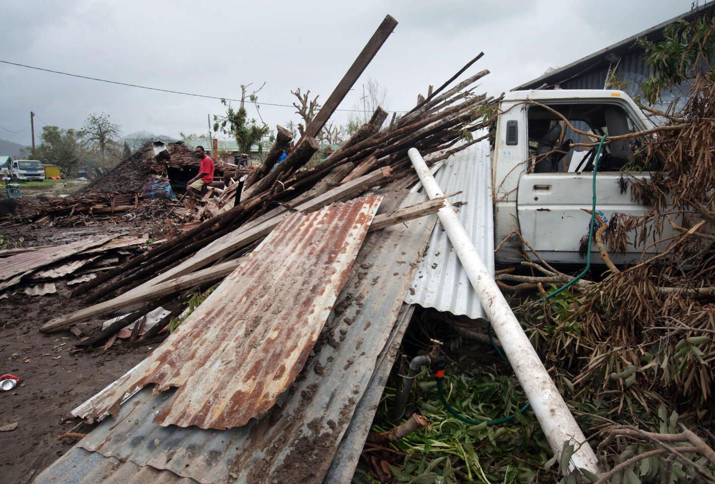 Residents outside Port Vila pile debris as they clean up after the cyclone.