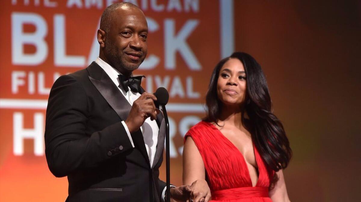 Jeff Friday, left, founder of the American Black Film Festival Honors, and Regina Hall, this year's host, speak at the ABFF Honors ceremony on Feb. 17 in Beverly Hills.