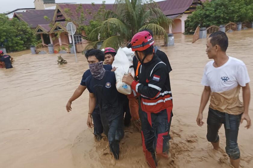 In this Friday, May 3, 2024, photo released by the Wajo Regional Disaster Management Agency (BPBD Wajo), rescuers carry a victim of a flood in Wajo, South Sulawesi, Indonesia. A flood and a landslide hit Indonesia's Sulawesi island, killing a number of people, officials said Saturday. (BPBD Wajo via AP)