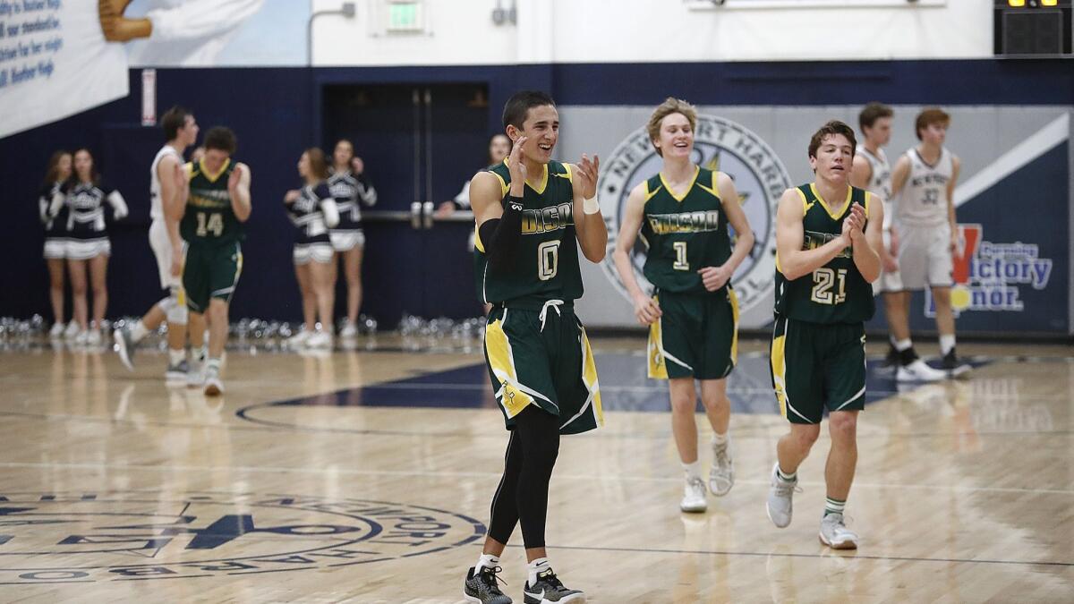David Atencio (0), Justin Strauss (1) and Kaden Headington (21) celebrate Edison's 50-45 victory over Newport Harbor, keeping the Chargers undefeated in the Sunset League.