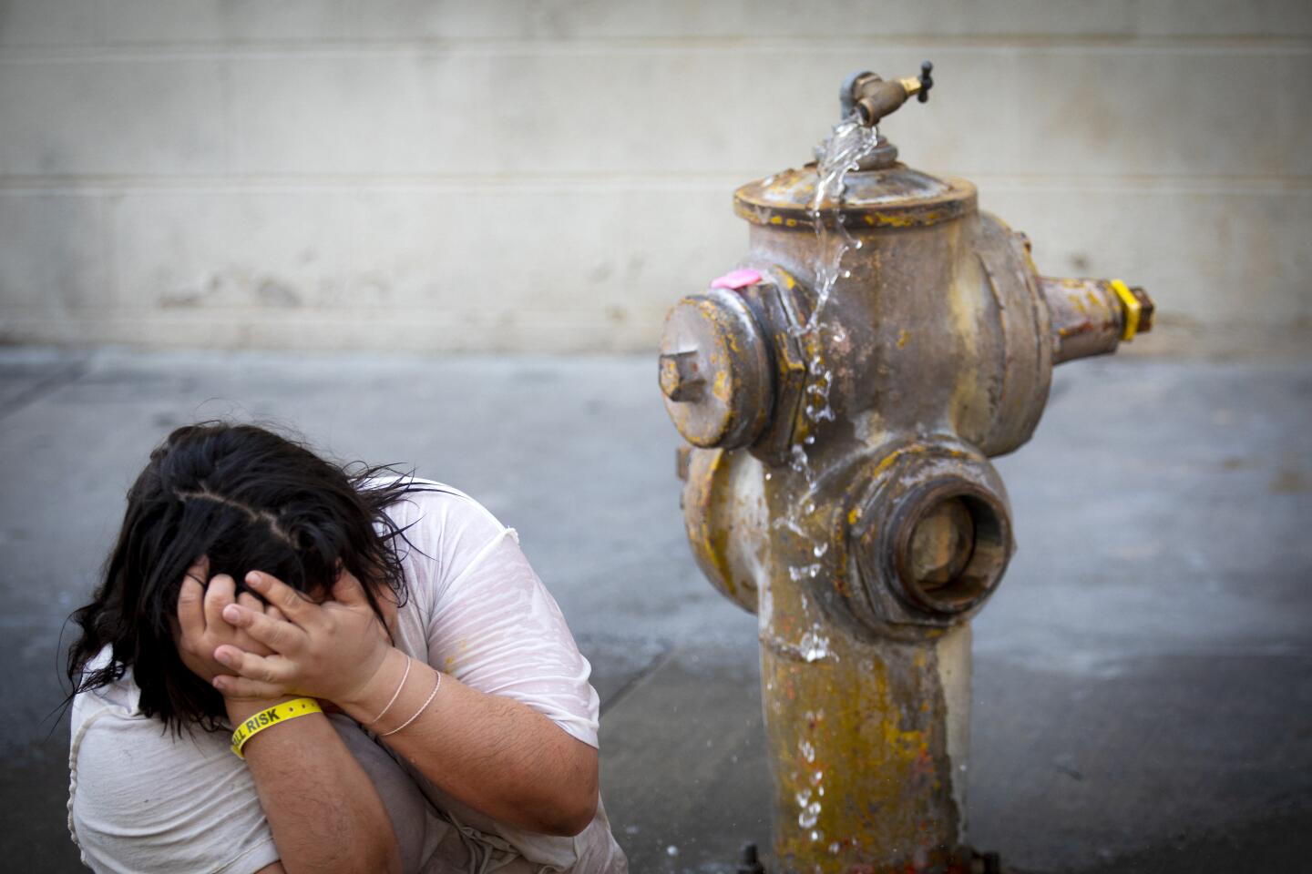 Monica Ruiz, 32, cools off on skid row in downtown Los Angeles.