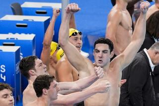 Members of the U.S. men's 4x100 meter freestyle relay team react after winning a gold medal 