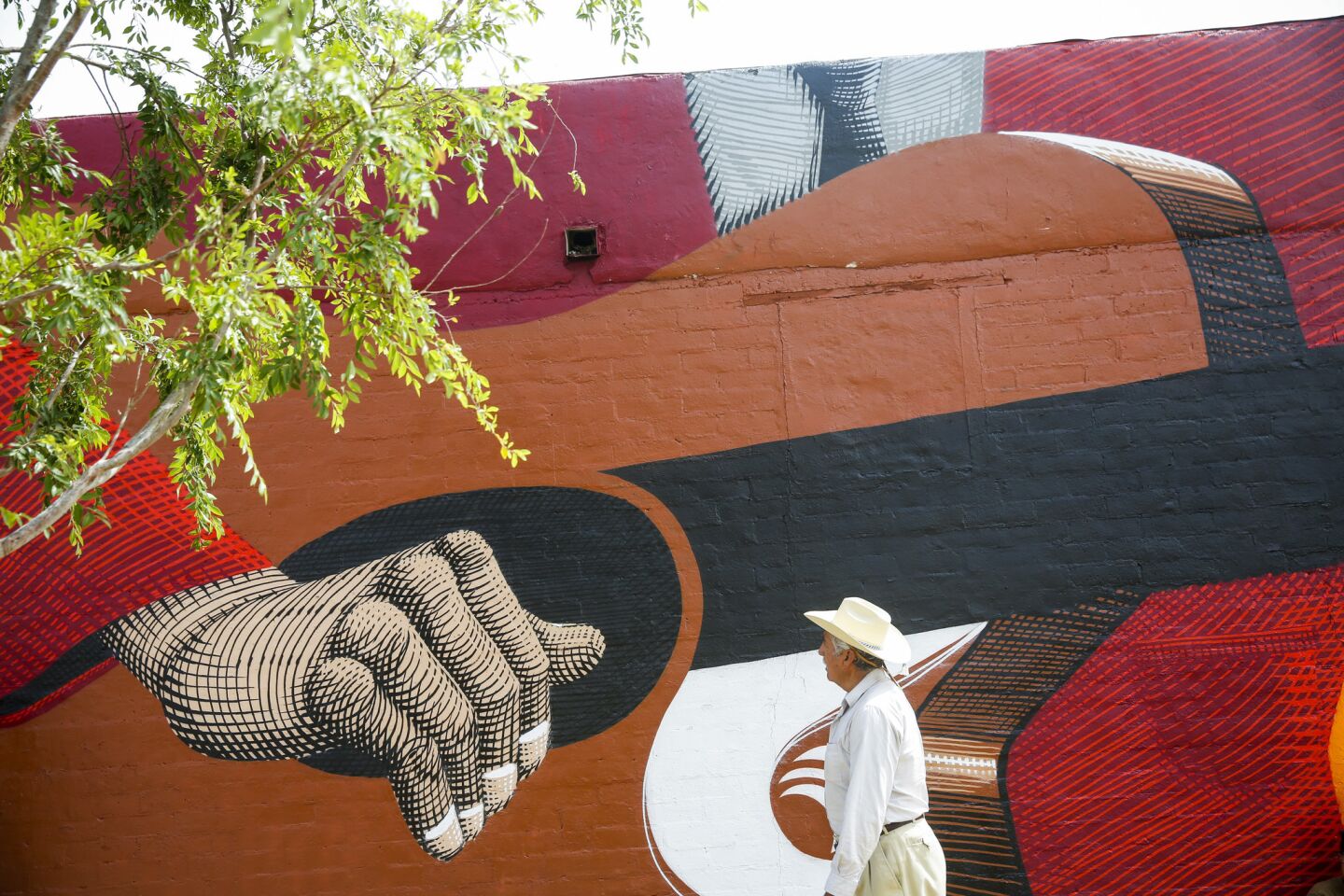 A man walks by the "A Banda," mural by internationally recognized Brazilian artist Nunca in 2014. It covers the side of a building in Coachella, about three hours south of Los Angeles.