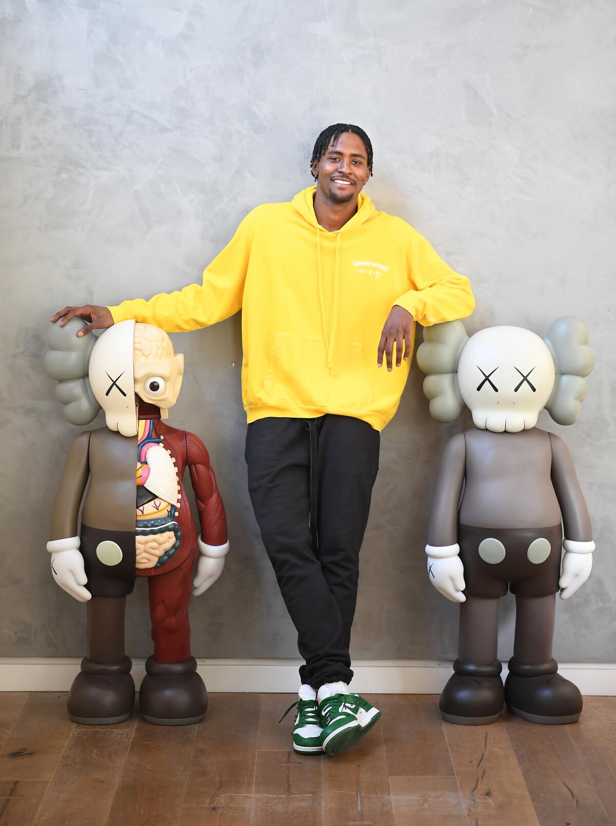 Maurice Harkless poses next to to a pair of KAWS figures at his home in Venice.