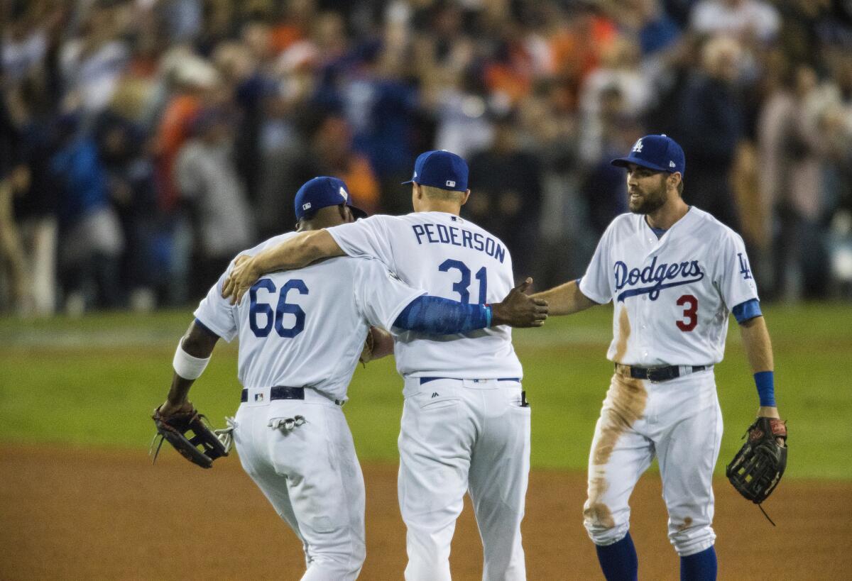 Yasiel Puig, left, Joc Pederson and Chris Taylor celebrate as the Dodgers win game 6 of the World Series 3-1 at Dodger Stadium.