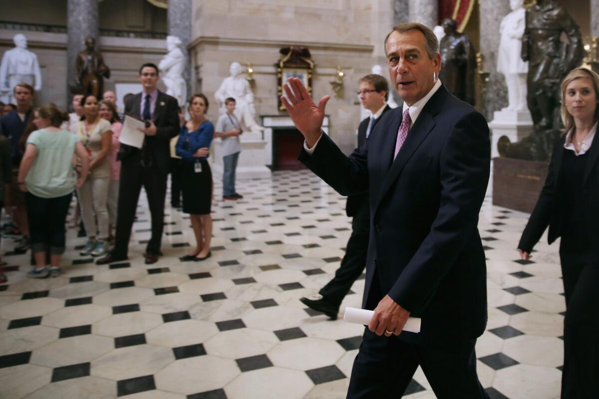 House Speaker John A. Boehner waves to tourists as he walks through Statuary Hall at the U.S. Capitol on the fourth day of the U.S. government shutdown.