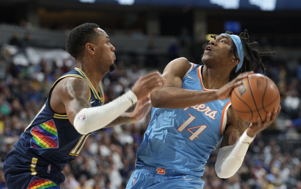Clippers guard Terance Mann is defended by Denver Nuggets guard Monte Morris.