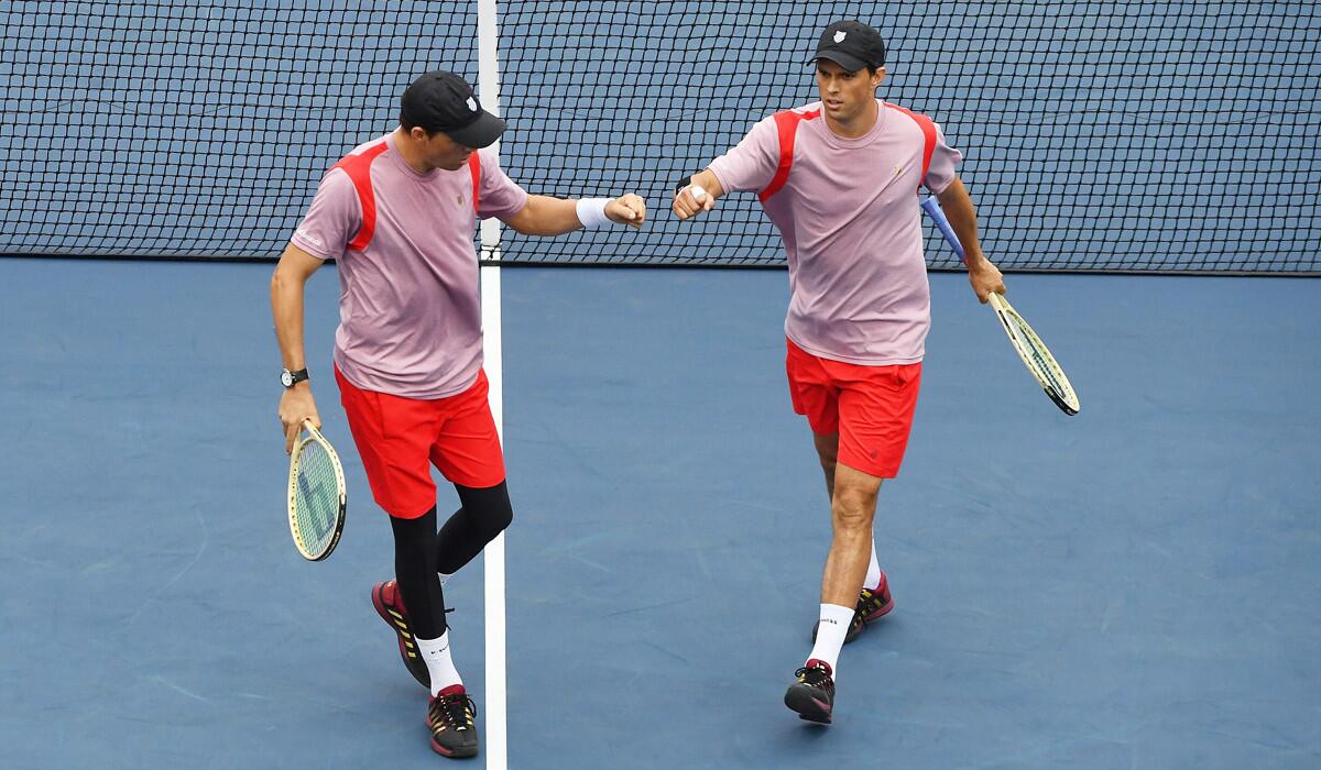 Bob Bryan, left, and Mike Bryan bump fists during their men's doubles quarterfinals match against Feliciano Lopez and Marc Lopez on Day 9 of the U.S. Open. The Spaniards won the match.
