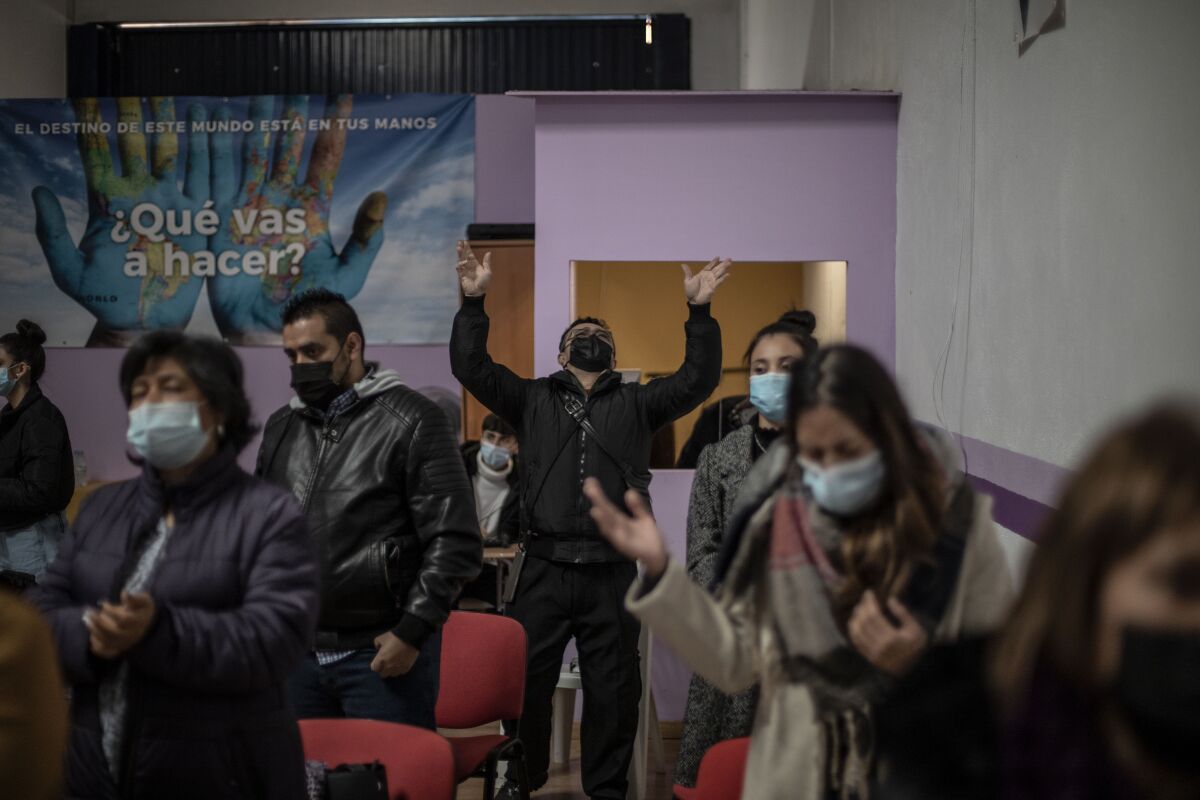 A man from Venezuela prays with other Latin-American parishioners during a Sunday Mass 