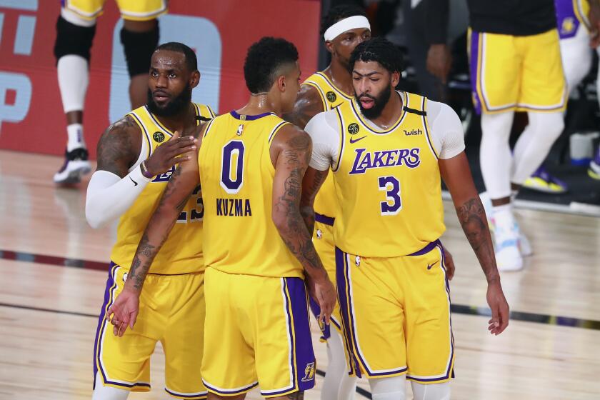 Los Angeles Lakers forward LeBron James (23) and forward Kyle Kuzma (0) and guard Kentavious Caldwell-Pope, second from right, and forward Anthony Davis (3) huddle during the first half against the Portland Trail Blazers during Game 2 of an NBA basketball first-round playoff series, Thursday, Aug. 20, 2020, in Lake Buena Vista, Fla. (Kim Klement/Pool Photo via AP)