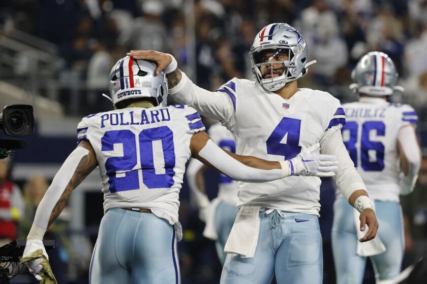Dallas Cowboys quarterback Dak Prescott (4) reacts with Tony Pollard (20) after Pollard scored a touchdown during the first half of an NFL football game against the Indianapolis Colts, Sunday, Dec. 4, 2022, in Arlington, Texas. (AP Photo/Michael Ainsworth)