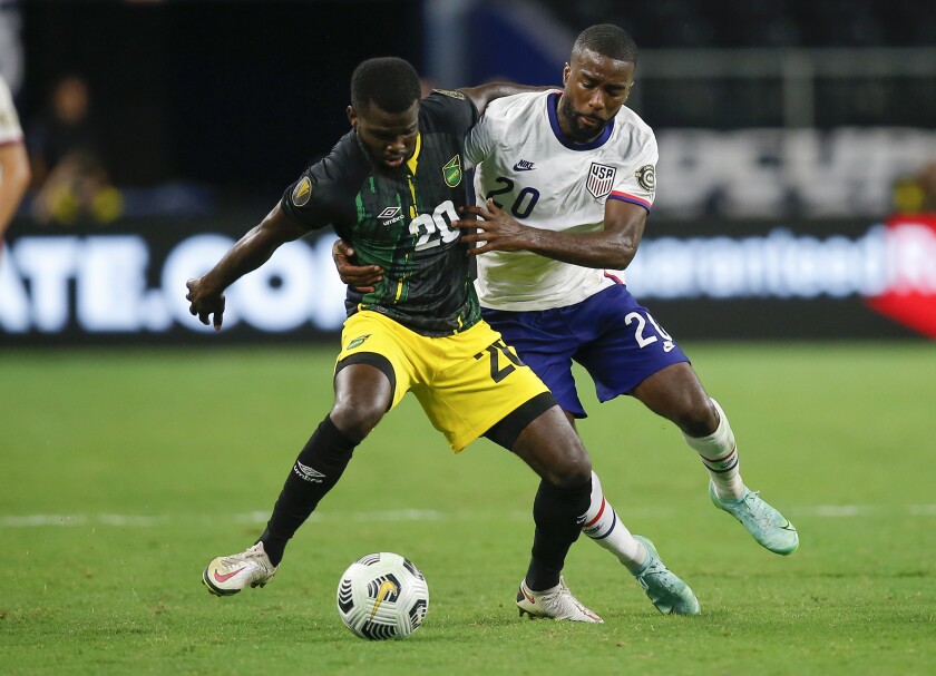 Jamaica's Kimar Lawrence, left, and American defender Chuck Moore vie for the ball on July 25 in Arlington, Texas.