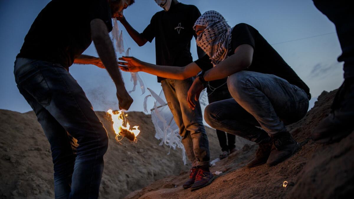 Palestinians test kites at the Bureij refugee camp. More than 7,400 acres of farmland and national parkland have been incinerated in hundreds of blazes sparked by fire-bearing kites and balloons.