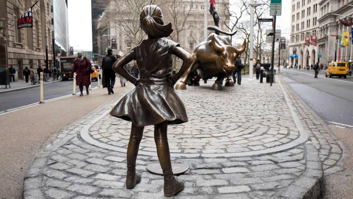 The "Fearless Girl" statue faces Wall Street's "Charging Bull" statue.