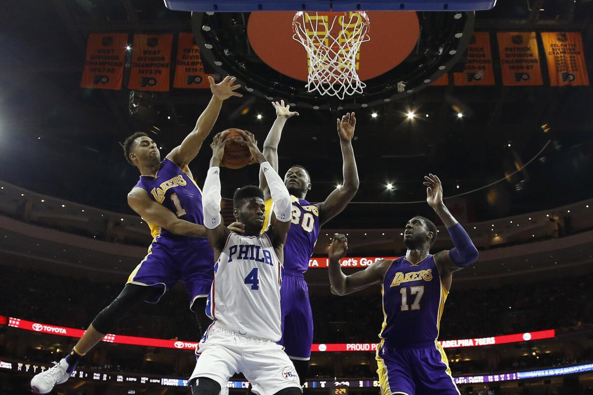 Lakers guard D'Angelo Russell (1) and forward Julius Randle (30) try to block the shot of 76ers forward Nerlens Noel (4) during the first half.