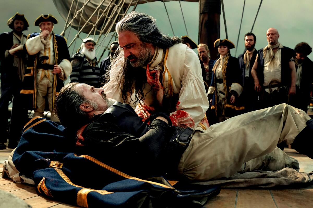 A bearded Taika Waititi as Blackbeard leans over Con O'Neill as Izzy Hands as he lays dying in "Our Flag Means Death."