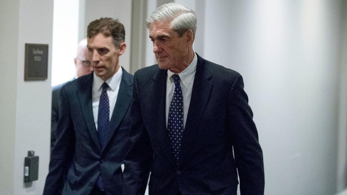 Special counsel Robert Mueller, right, leaves a Capitol Hill meeting in June.