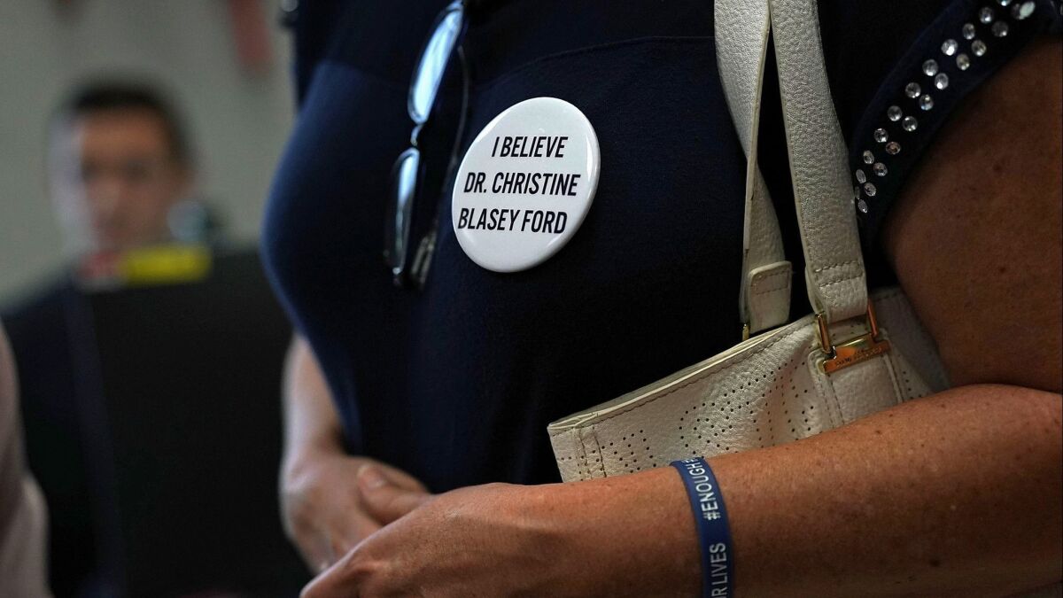 An activist wears a button in support of Christine Blasey Ford, who has accused Supreme Court nominee Judge Brett Kavanaugh of sexual assault.