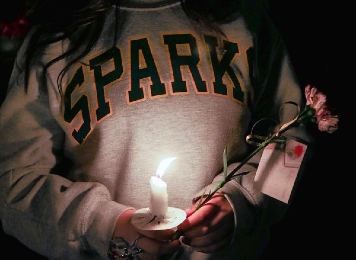 Hundreds of people attend a candlelight vigil at Sparks Middle School in Sparks, Nev., for slain teacher Michael Landsberry and two students who were injured in a shooting Monday. The shooter, who killed himself after opening fire, has been identified as Jose Reyes, 12.