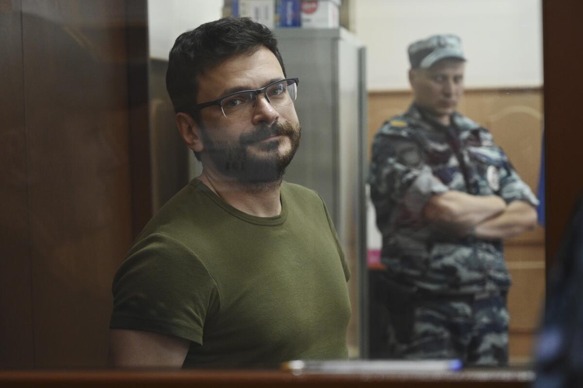 Russian opposition activist and a municipal deputy of the Krasnoselsky district Ilya Yashin stands in a cage at a court room during a hearing on his detention the Basmanny district court in Moscow, Russia, Wednesday, July 13, 2022. Yashin faces charges under a new law making it a crime to spread false information about the military that carry a potential sentence of up to 15 years in prison. (AP Photo/Dmitry Serebryakov)