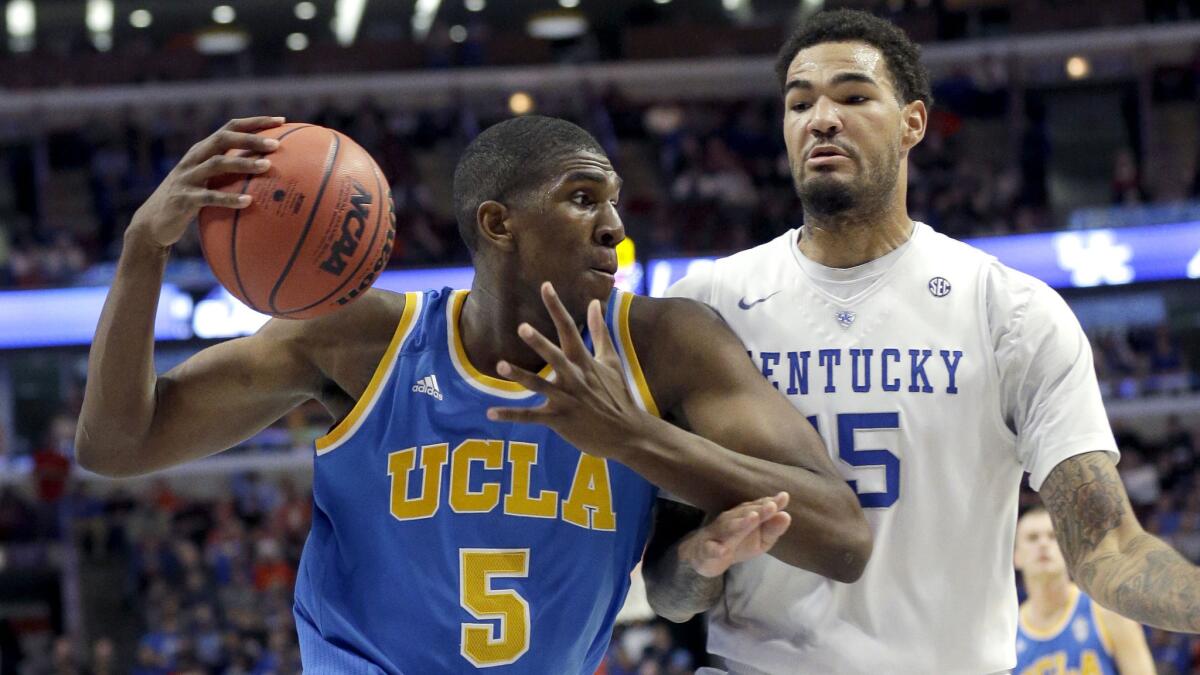 UCLA forward Kevon Looney, left, drives to the basket on Kentucky forward Willie Cauley-Stein during the first half of the Bruins' loss in Chicago.