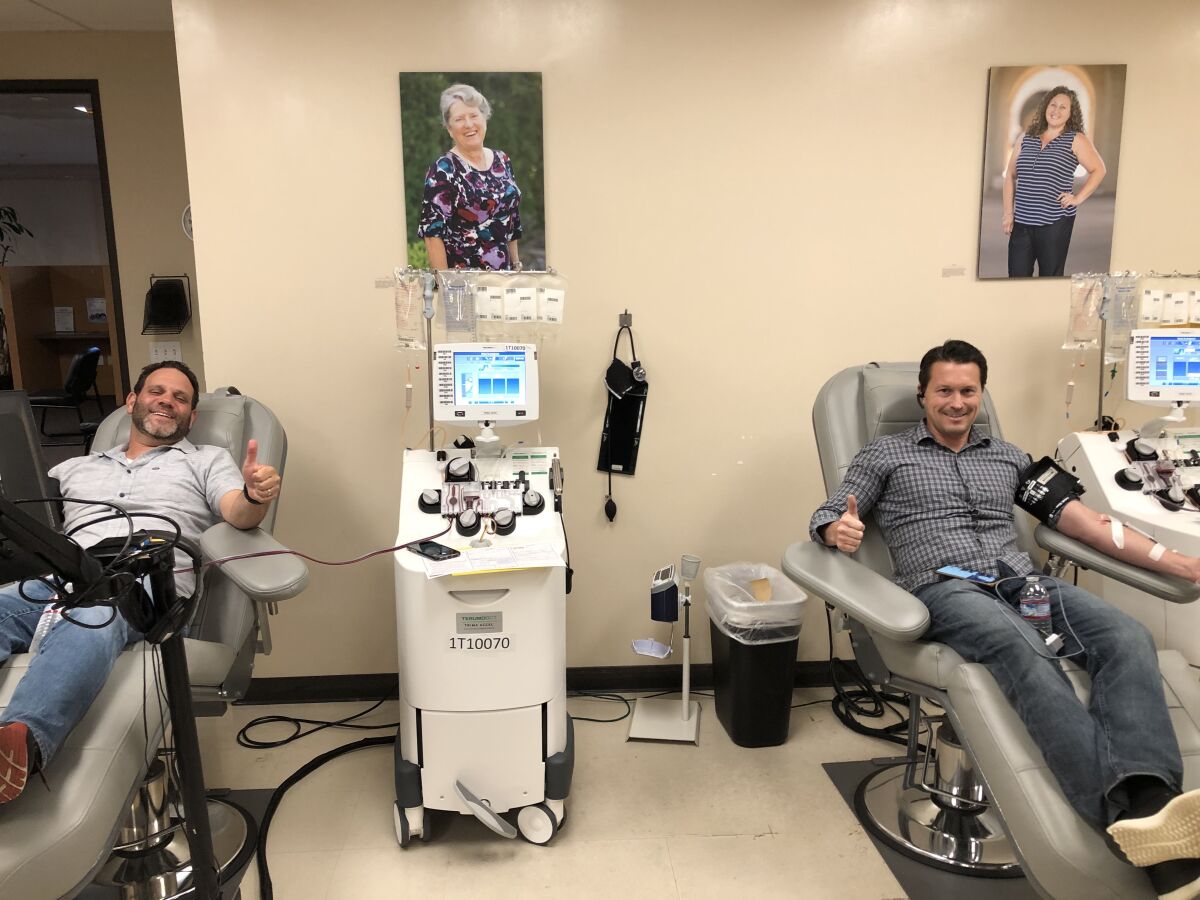 David Rodman, left, and Tim Callan donate plasma to the San Diego Blood Bank. The friends contracted COVID-19 on a group ski trip.