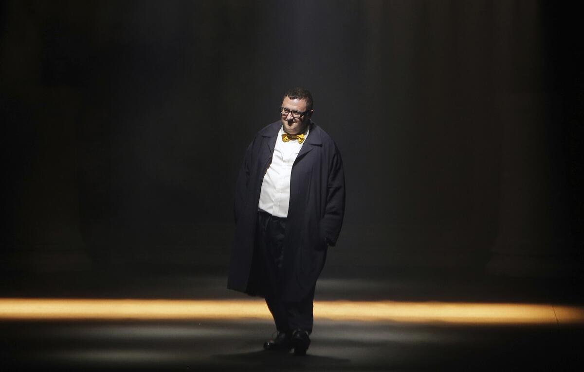 Alber Elbaz, in suit and bow tie, smiles onstage.