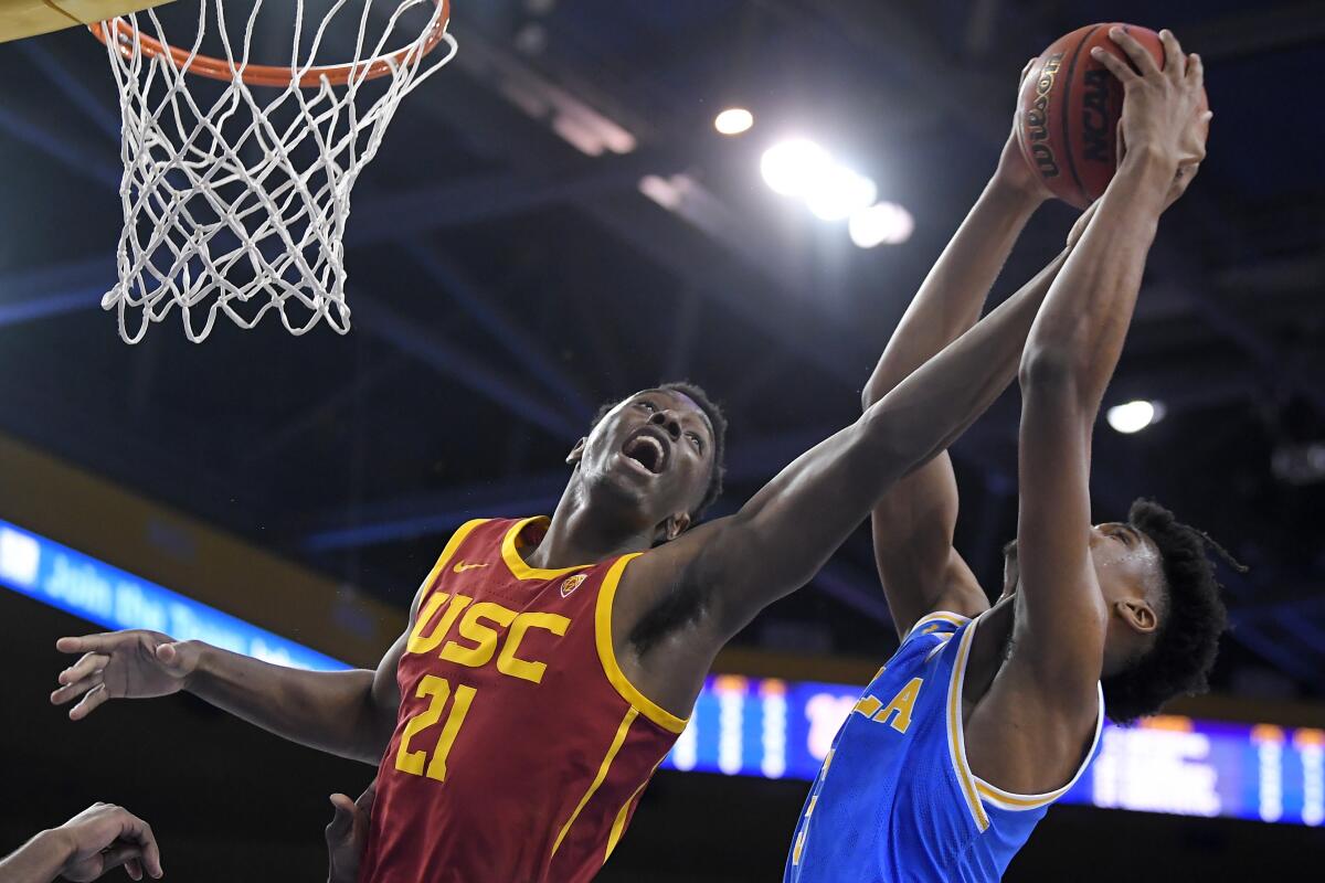 USC forward Onyeka Okongwu, left, and UCLA guard Chris Smith reach for a rebound during the first half on Saturday at Pauley Pavilion.