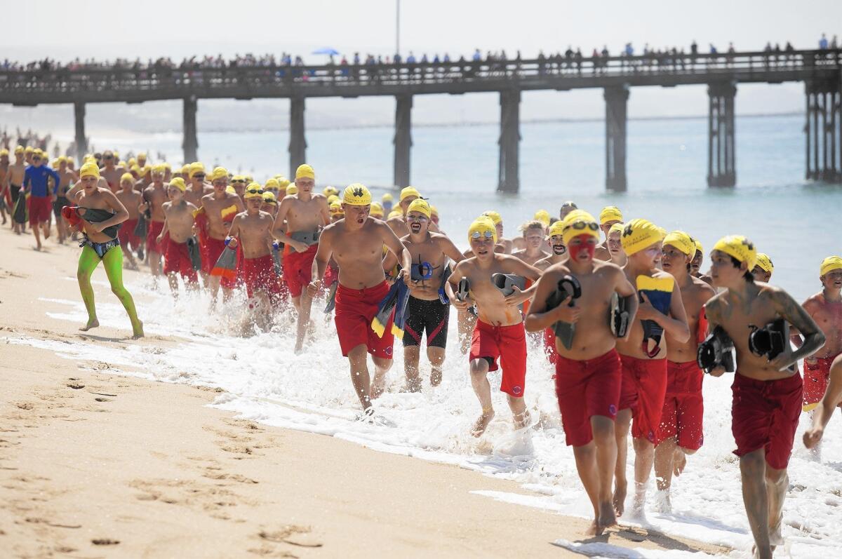 The boys' group B run out toward 10th Street during the annual monster mile event for the Newport Beach junior lifeguards at the Balboa Pier on Thursday, July 30.