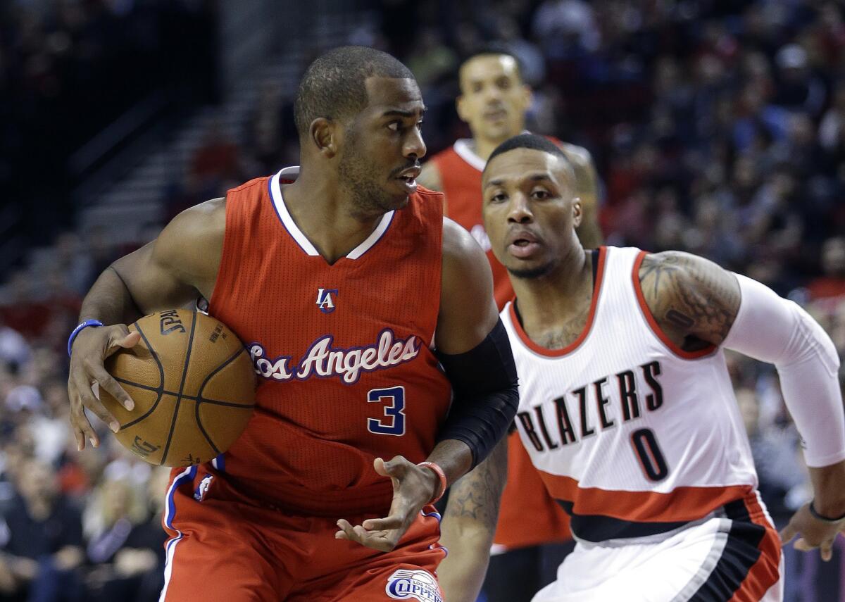 Clippers point guard Chirs Paul drives against Trail Blazers point guard Damian Lillard in the first half.