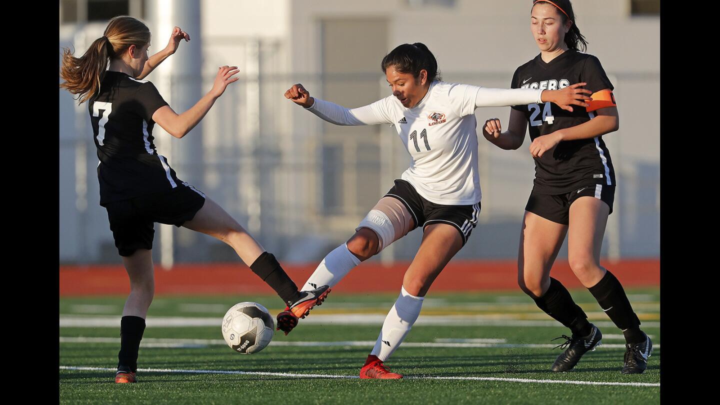 Los Amigos High's Vidalia Abarca (11) battles against South Pasadena's Emily Dunn (7) and Riley Segal (24) during the first half in the semifinals of the CIF Southern Section Division 5 playoffs on Tuesday at Garden Grove High School.