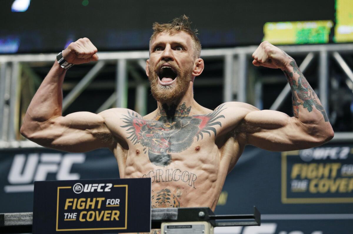 Conor McGregor poses on the scale during the Dec. 11 weigh-in for UFC 194 in Las Vegas.