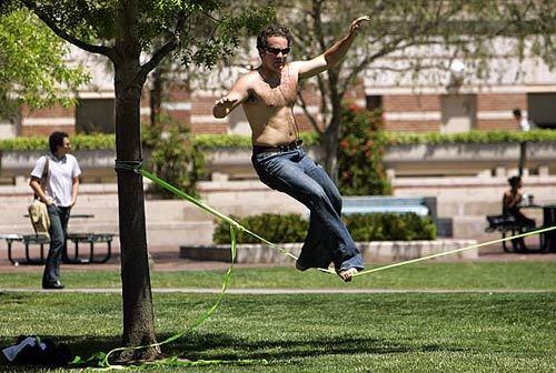Oren Tuchin, 32, a grad student in the business school at USC, makes his way across a 45-foot line made of nylon climbing rope, tied to a couple of trees on the school campus. Tuchin said he does this for exercise three days a week, about an hour a day. " You don't realize you're getting a workout because it's so much fun," Tuchin said.