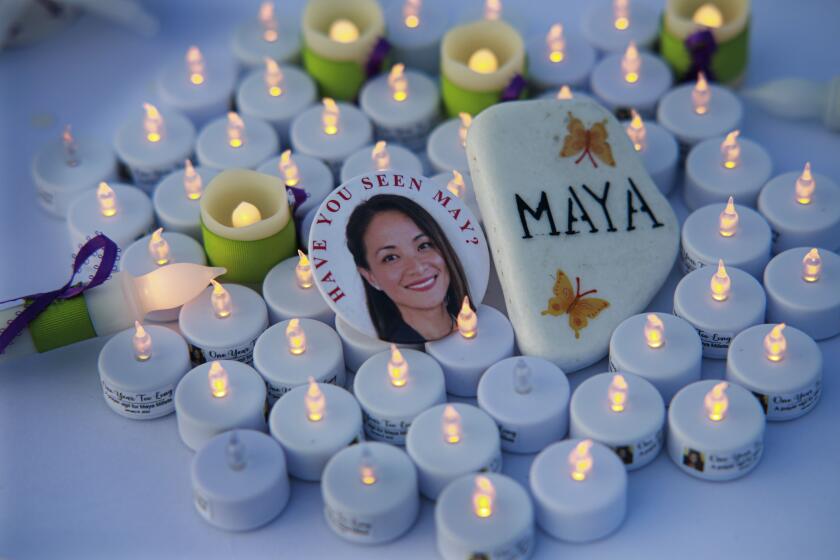 Button and candles at a prayer vigil in Chula Vista for May "Maya" Millete on Jan. 8, 2022.