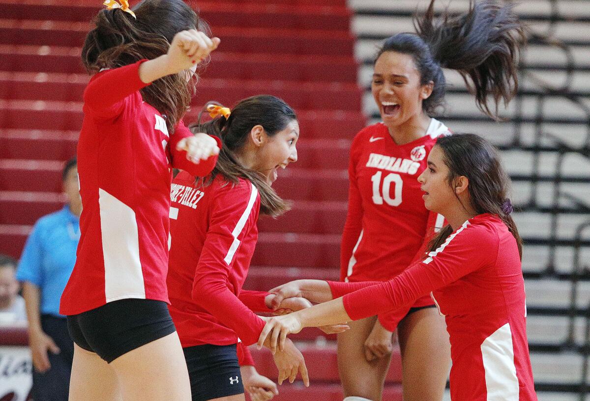 The Burroughs team celebrates a point won against Arcadia in a Pacific League girls' volleyball match at Arcadia High School on Thursday, September 19, 2019. (Tim Berger / Staff Photographer)