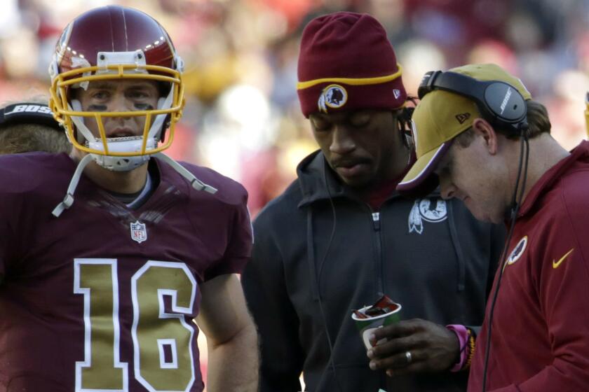 Washington Redskins quarterback Colt McCoy, left, stands with quarterback Robert Griffin III, center, and Coach Jay Gruden during Sunday's win over the Tennessee Titans.