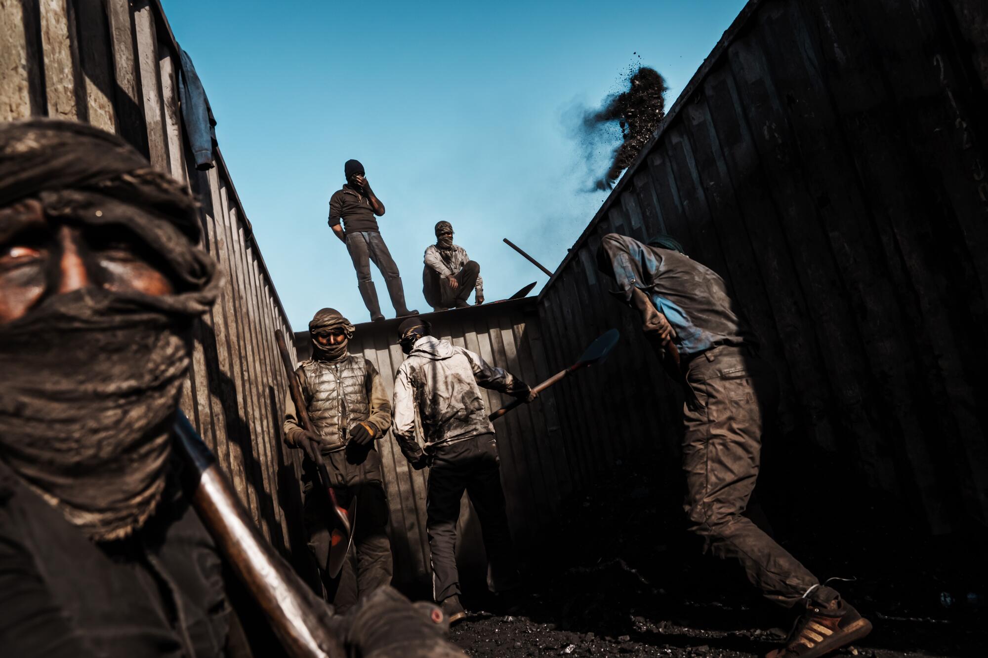 Men shoveling coal onto trucks