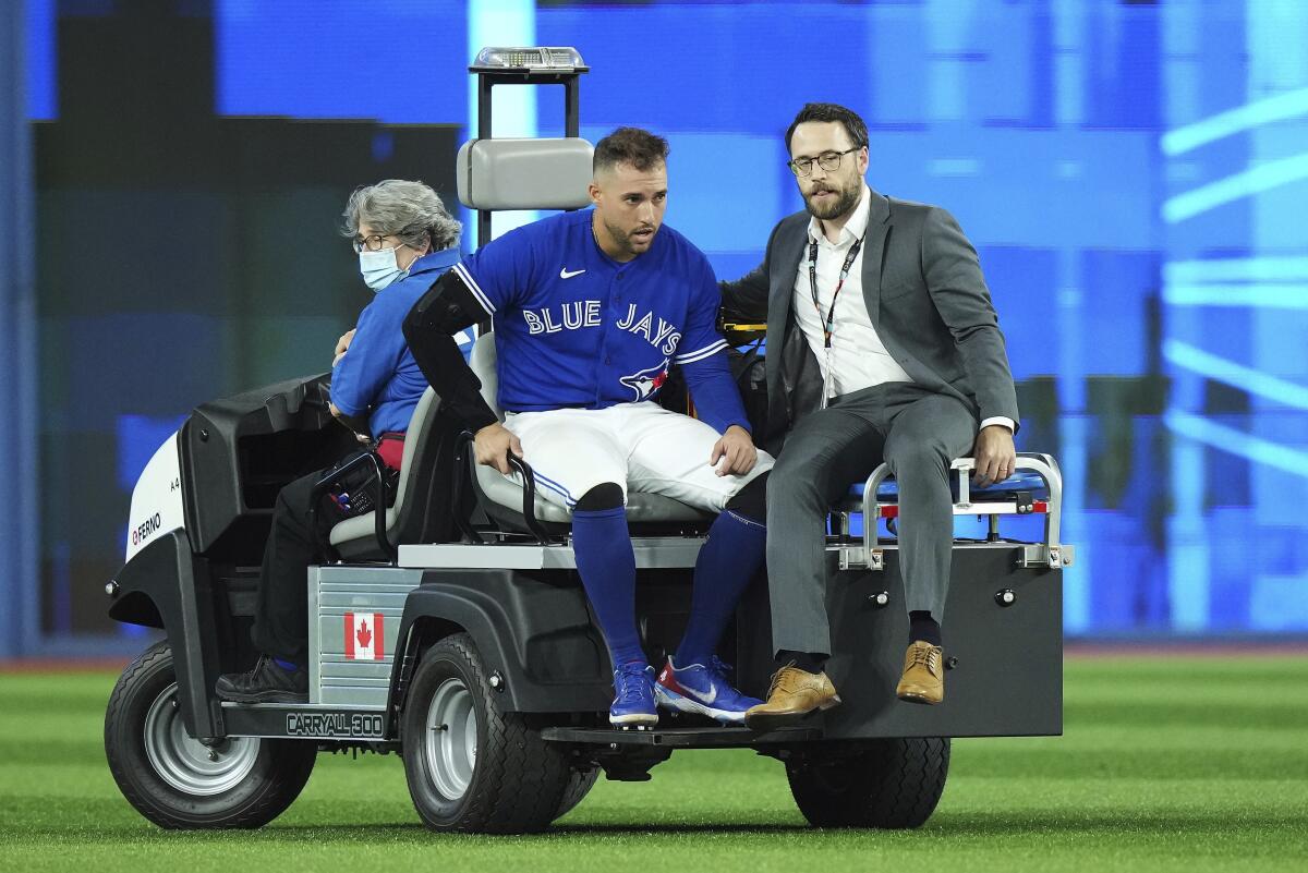Toronto Blue Jays center fielder George Springer leaves the field on a cart after being injured in a collision with shortstop Bo Bichette during the eighth inning of Game 2 of a baseball AL wild-card playoff series against the Seattle Mariners on Saturday, Oct. 8, 2022, in Toronto. (Nathan Denette/The Canadian Press via AP)